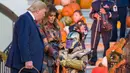 Halloween Ala Trump: Presiden Donald Trump dan ibu negara Melania Trump membagikan permen kepada anak-anak selama acara trick-or-treat Halloween di Gedung Putih, 28 Oktober 2019. Halloween memang menjadi salah satu perayaan terbesar di banyak negara di seluruh dunia. (AP/Alex Brandon)
