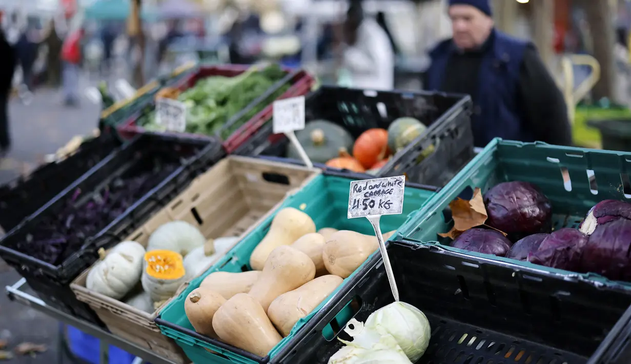 Sebuah tanda menampilkan harga sayur-sayuran di kios pasar di Walthamstow Market di London timur London timur, Minggu (22/11/2021). Inflasi Inggris telah mencapai level tertinggi 10 tahun karena tagihan energi rumah tangga meroket, menurut data minggu lalu. (Tolga Akmen/AFP)