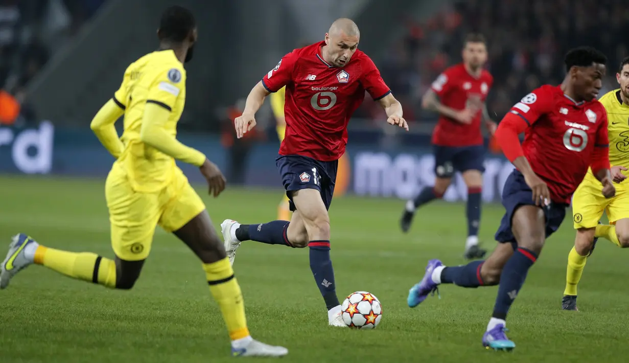 Penyerang Lille, Burak Yilmaz menggiring bola saat bertanding melawan Chelsea pada pertandingan leg kedua babak 16 besar Liga Champions di stadion Stade Pierre Mauroy, Prancis utara, Kamis (17/3/2022). Chelsea menang atas Lille 3-0. (AP Photo/Michel Spingler)