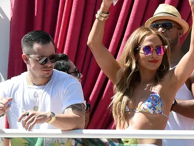 Penyanyi Jennifer Lopez saat berjoget didampingi Koreografer Casper Smart saat menjadi host di acara "Karnaval Del Sol" pesta kolam renang di Drai Beach Club - Nightclub di The Cromwell Las Vegas pada 29 Mei 2016. (Ethan Miller/Getty Images/AFP)