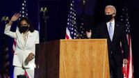 Presiden terpilih Joe Biden dan Wakil Presiden terpilih Kamala Harris melambaikan tangan ke kerumunan saat menyampaikan pidato kemenangan Pilpres AS 2020 di Wilmington, Delaware, Amerika Serikat, Sabtu (7/11/2020). Joe Biden dan Kamala Harris memenangkan Pilpres AS 2020. (AP Photo/Andrew Harnik)