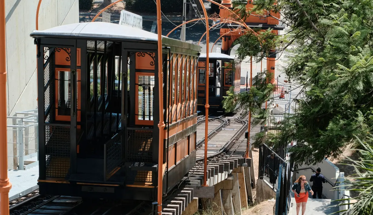 Seorang pejalan kaki melintas di sebelah kereta api Angels Flight di pusat kota Los Angeles, AS (28/8). Kereta api Angels Flight memilik rel sepanjang 91 meter dan dijuluki rel paling pendek di dunia. (AP Photo / Richard Vogel)