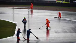 Pekerja menyapu air hujan ke luar lintasan saat sesi latihan dan kualifikasi kualifikasi MotoGP Thailand 2019 di Sirkuit Internasional Buriram, Sabtu (5/10/2019). Hujan deras mengakibatkan sesi latihan dan kualifikasi MotoGP Thailand 2019 ditunda. (Lillian SUWANRUMPHA/AFP)