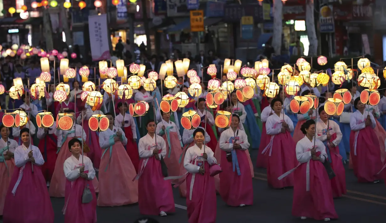 Sejumlah wanita membawa lampion saat Lotus Lantern Festival di Seoul, Korea Selatan, Sabtu (29/4). Parade ini bagian dari jelang perayaan ulang tahun Buddha yang jatuh pada 3 Mei 2017. (AP Photo / Lee Jin-man)
