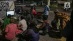 Sejumlah warga menyaksikan pertandingan laga final leg pertama Piala AFF 2020 antara Indonesia melawan Thailand melalui televisi di sejumlah tempat di kawasa Jakarta, Rabu (29/12/2021). Timnas Indonesia harus kalah dengan skor 0-4 atas Thailand. (Liputan6.com/Faizal Fanani)