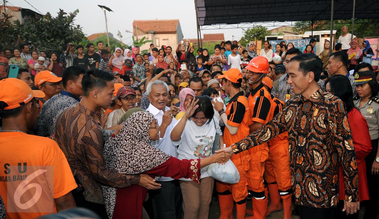 Warga antri untuk bersalaman dengan Presiden RI Joko Widodo di Lapangan Bedeng, Pisangan Baru, Jakarta, Selasa (8/9/2015). Kedatangan Presiden Jokowi untuk memberikan sejumlah paket sembako dan buku kepada warga. (Liputan6.com/Helmi Fithriansyah)