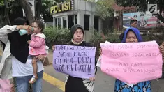 Kaum ibu yang tergabung dalam Emak-Emak Indonesia membentangkan poster saat menggelar aksi di depan Gedung Polda Metro Jaya, Jakarta, Minggu (29/9/2019). Mereka mengecam tindakan represif aparat terhadap mahasiswa dan pelajar dalam demonstrasi 23-25 September 2019. (merdeka.com/Iqbal S. Nugroho)