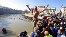 Simone Carabella dari Italia menyapa orang-orang saat dia bersiap untuk melompat ke Sungai Tiber dari Jembatan Cavour setinggi 18 meter (59 kaki) untuk merayakan Tahun Baru di Roma, 1 Januari 2022. (AP Photo/Riccardo De Luca)