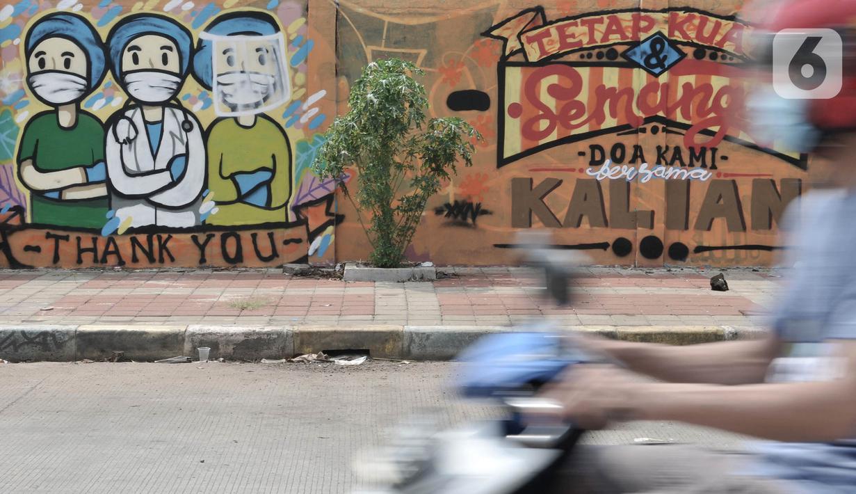 Pengendara melintas di depan mural dukungan untuk tim medis Covid-19 di kawasan Sunter, Jakarta, Rabu (27/5/2020). Mural bergambarkan sosok tim medis dan ungkapan doa ini berada di seberang RS Darurat Wisma Atlet yang dibuat oleh Karang Taruna Kelurahan Sunter Jaya. (merdeka.com/Iqbal S. Nugroho)