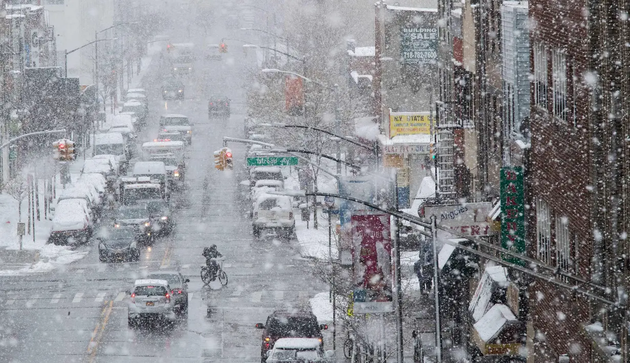 Suasana arus lalu lintas saat badai salju di distrik Brooklyn, New York (21/3). Badai salju yang melanda sebagian Amerika Serikat telah membawa salju dan angin kencang. (AP Photo / Mary Altaffer)