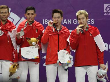 Ganda putra Indonesia, Kevin Sanjaya S/Marcus F Gideon dan Fajar Alfian/M Rian Ardianto di podium kemenangan usai Final Bulutangkis Asian Games 2018 di Istora GBK, Jakarta, Selasa (28/8). Indonesia meraih emas dan perak. (Liputan6.com/Helmi Fithriansyah)