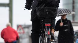 Warga memakai sepeda melalui salju di Munich, Jerman selatan, (18/4). Hujan salju yang melanda kawasan ini tidak menyurutkan warga untuk tetap beraktivitas. (AFP PHOTO / dpa / Matthias Balk / Jerman OUT)