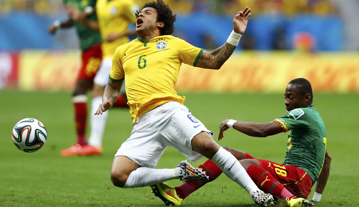 Pemain belakang Brasil, Marcelo (kiri), mendapat tackling keras dari gelandang Kamerun, Enoh Eyong, saat berlaga di penyisihan Piala Dunia 2014 Grup A di Stadion Nasional Brasil, (24/6/2014). (REUTERS/ominic Ebenbichler)