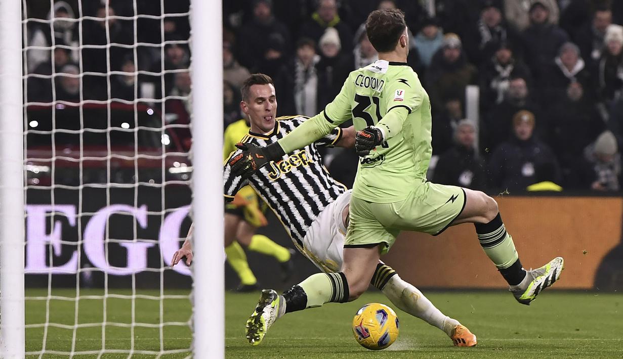Pemain Juventus, Arkadiusz Milik (kiri) berusaha melewati kiper Frosinone, Michele Cerofolini untuk mencetak gol pada babak perempat final Coppa Italia di Allianz Stadium, Juventus, Jumat (12/01/2024) dini hari WIB. (AP Photo/LaPresse/Fabio Ferrari)