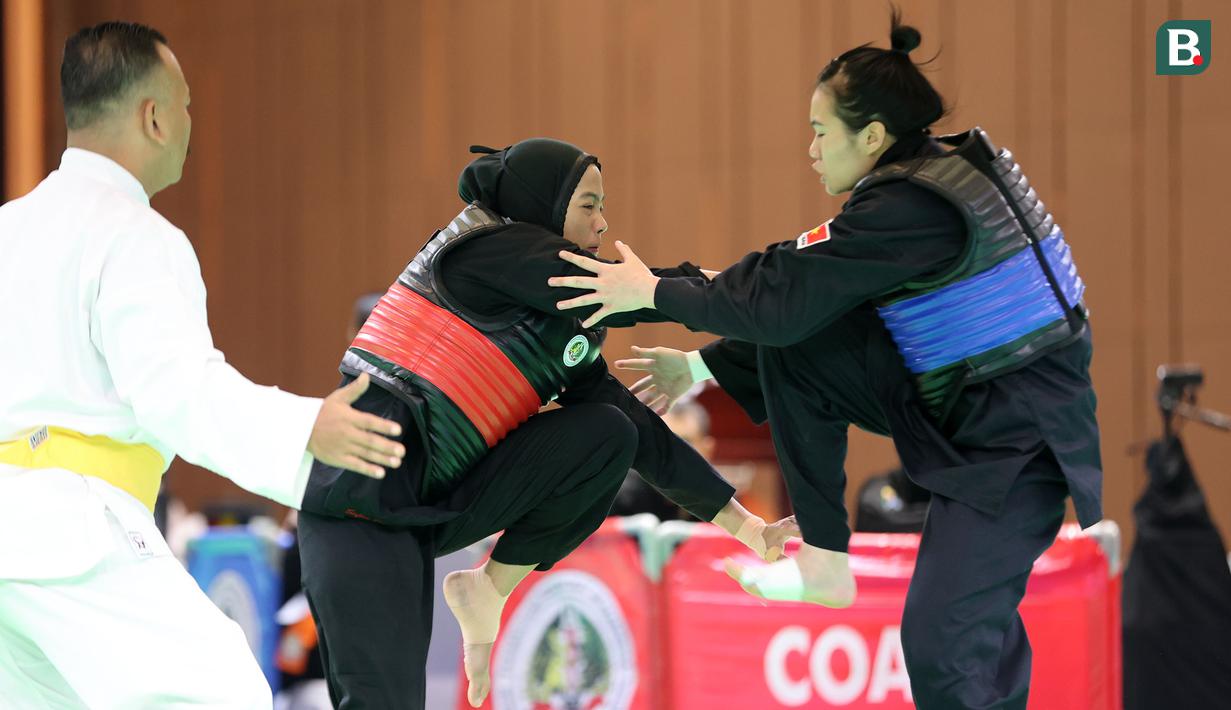Atlet pencak silat putri Indonesia, Safira Dwi Meilani (kiri) bertanding melawan wakil Vietnam, Nguyen Huang Hong An pada nomor tanding putri kelas B Pencak Silat SEA Games 2023 di Chroy Changvar International Convention and Exhibition Center, Phnom Penh, Kamboja, Rabu (10/05/2023). (Bola.com/Abdul Aziz)