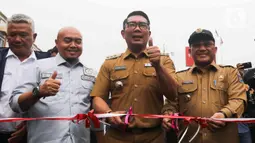 Gubernur Jawa Barat Ridwan Kamil bersama Walikota Depok Mohammad Idris bersiap mengunting pita untuk meresmikan Jalan Underpass Dewi Sartika di Depok, Jawa Barat, Selasa (17/1/2023). Diketahui, proyek pembangunan underpass Jalan Dewi Sartika ini menelan biaya sebesar Rp180 miliar. (Liputan6.com/Herman Zakharia)