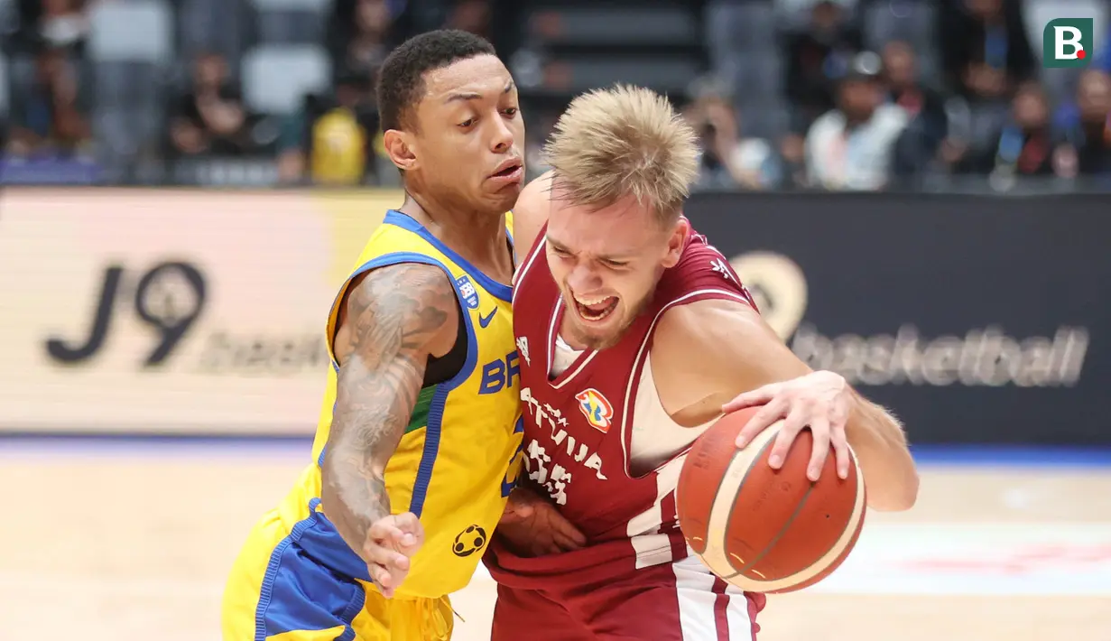 Pebasket Latvia, Arturs Zagars, berebut bola dengan pebasket Brasil, Yago Santos, pada laga Piala Dunia FIBA 2023 di Indonesia Arena, Minggu (3/9/2023). Latvia menang dengan skor 104-84. (Bola.com/M Iqbal Ichsan)