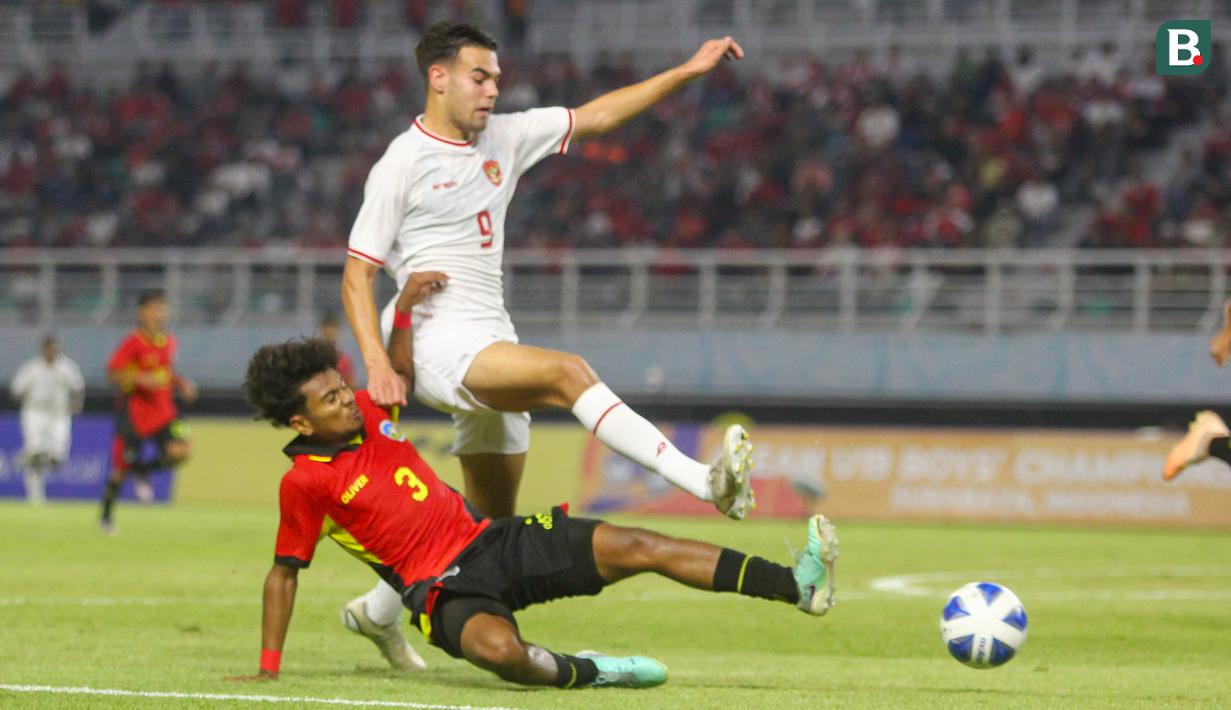 <p>Pemain Timnas Timor Leste U-19, Carol Waitilia Moreira (bawah) melakukan tekel terhadap pemain Timnas Indonesia U-19 Jens Raven pada laga matchday ketiga Grup A Piala AFF U-19 di Stadion Gelora Bung Tomo, Surabaya. Selasa (23/7/2024). (Bola.com/Aditya Wany)</p>