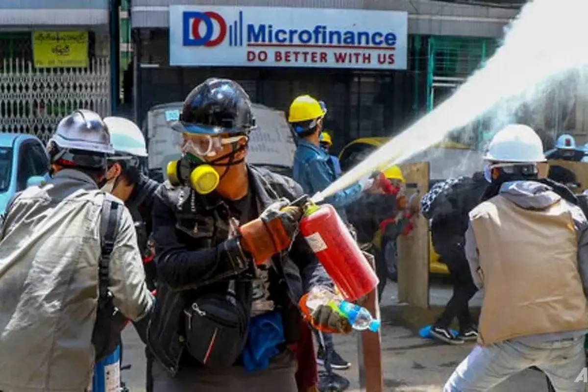Pengunjuk rasa anti-kudeta mengeluarkan alat pemadam kebakaran untuk melawan dampak gas air mata yang ditembakkan oleh polisi selama demonstrasi di Yangon, Myanmar, pada 4 Maret 2021.