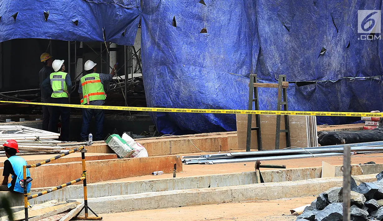 Petugas melihat bangunan proyek Apartemen Pakubuwono Spring 3 yang ambruk di Jalan Teuku Cut Nyak Arief, Jakarta, Rabu (27/12). Akibat insiden ini, tiga orang tewas. (Liputan6.com/JohanTallo)