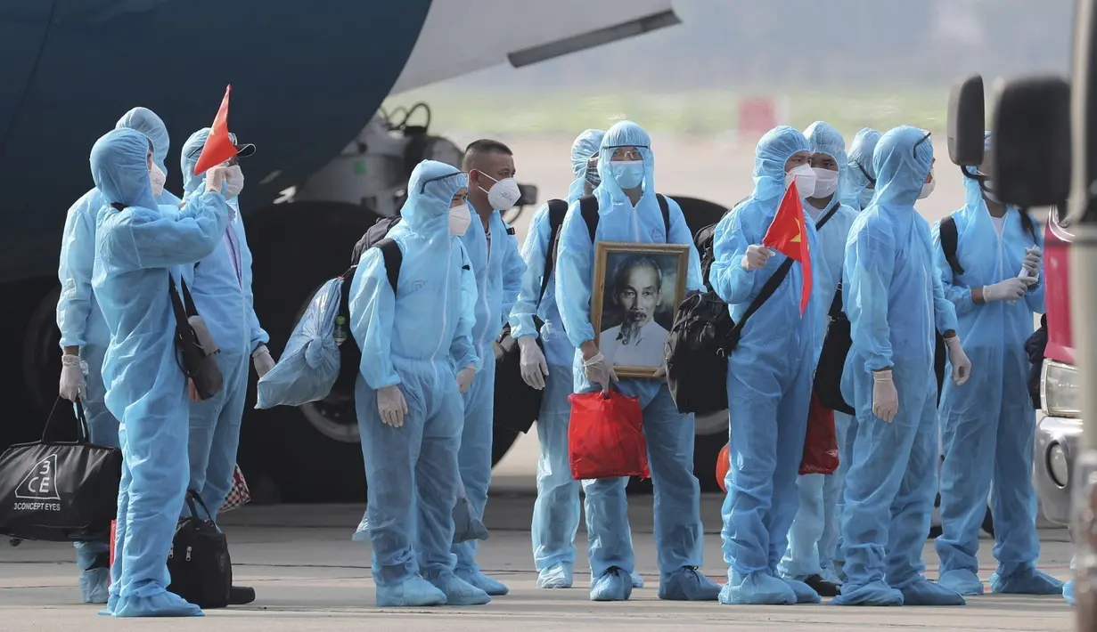 Pasien COVID-19 asal Vietnam mengenakan alat pelindung diri saat tiba di Bandara Noi Bai, Hanoi, Vietnam, Rabu (29/7/2020). Sebanyak 129 pekerja asal Vietnam dipulangkan dari Equatorial Guinea untuk mendapat perawatan COVID-19. (Tran Huy Hung/VNA via AP)