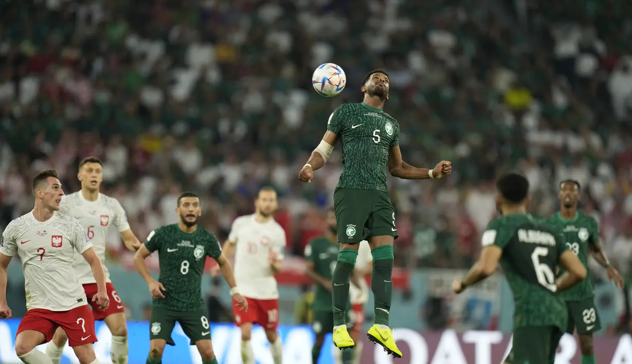 Bek Arab Saudi, Ali Al-Bulaihi berusaha menyundul bola saat bertanding melawan Polandia selama pertandingan grup C Piala Dunia 2022 Qatar di Education City Stadium di Al Rayyan, Qatar, Sabtu (26/11/2022). Polandia menang atas Arab Saudi dengan skor 2-0. (AP Photo/Francisco Seco)