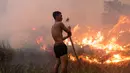 Foto yang diambil pada tanggal 2 Oktober 2023 ini menunjukkan seorang pemilik perkebunan cabai berusaha memadamkan kebakaran lahan gambut untuk melindungi lahan miliknya di Ogan Ilir, Sumatra Selatan. (Al ZULKIFLI / AFP)