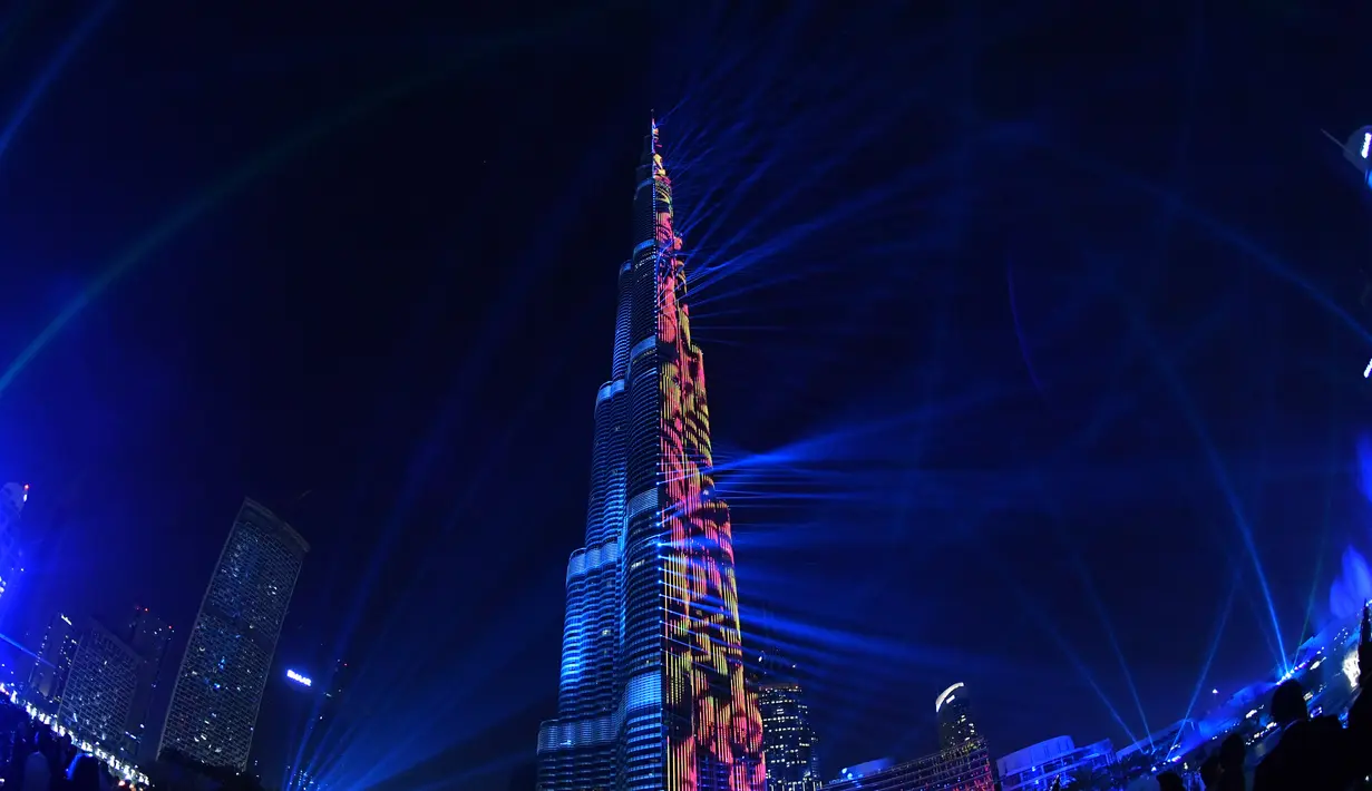 Menara tertinggi di dunia, Burj Khalifa, memancarkan sinar laser pada malam perayaan Tahun Baru di Dubai, 1 Januari 2018. Burj Khalifa bermandikan sinar laser hijau, putih, hitam dan merah yang mewakili  warna bendera negara itu. (Giuseppe CACACE/AFP)