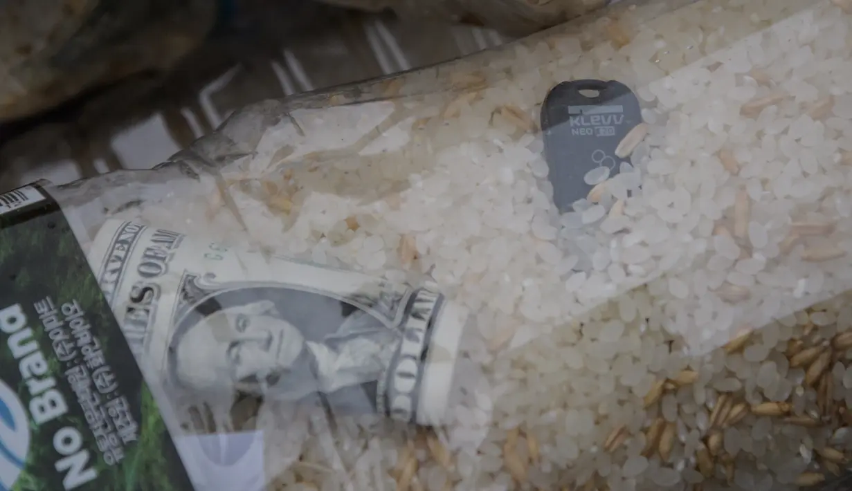 Botol berisi beras, uang dan USB sebelum diapungkan ke laut oleh para pembelot Korea Utara di pulau Ganghwa, barat Seoul, Selasa (1/5). USB berisi film, program televisi hingga video K-pop untuk menunjukkan kebebasan di Korea Selatan. (AFP/ED JONES)
