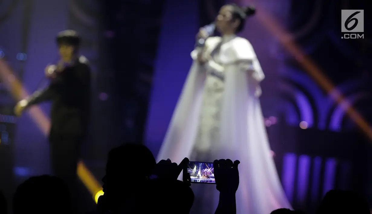 Penoton mengambil gambar saat duet Putri dengan Henry Lamiri dan Delicacy dalam grand finalis Dangdut Academy 4 atau D'Academy 4 di Studio 5 Indosiar, Jakarta, Jumat (19/5). (Liputan6.com/Faizal Fanani)