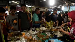 Warga muslim Thailand membeli makanan di pasar sebelum berbuka puasa selama bulan suci Ramadan di Narathiwat (7/5/2019). Umat muslim di seluruh dunia tengah menjalani puasa pada bulan ramadan. (AFP Photo/Madaree Tohlala)