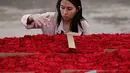 Penduduk setempat mengitung bunga mawar untuk pembuatan piramida Cochasqui dalam upaya pemecahan Guinness World Records di Tabacundo, Ekuador, 20 Juli 2018. Piramida dibangun  oleh 1.500 orang yang bekerja 16 jam sehari selama 1 minggu. (AP/Dolores Ochoa)