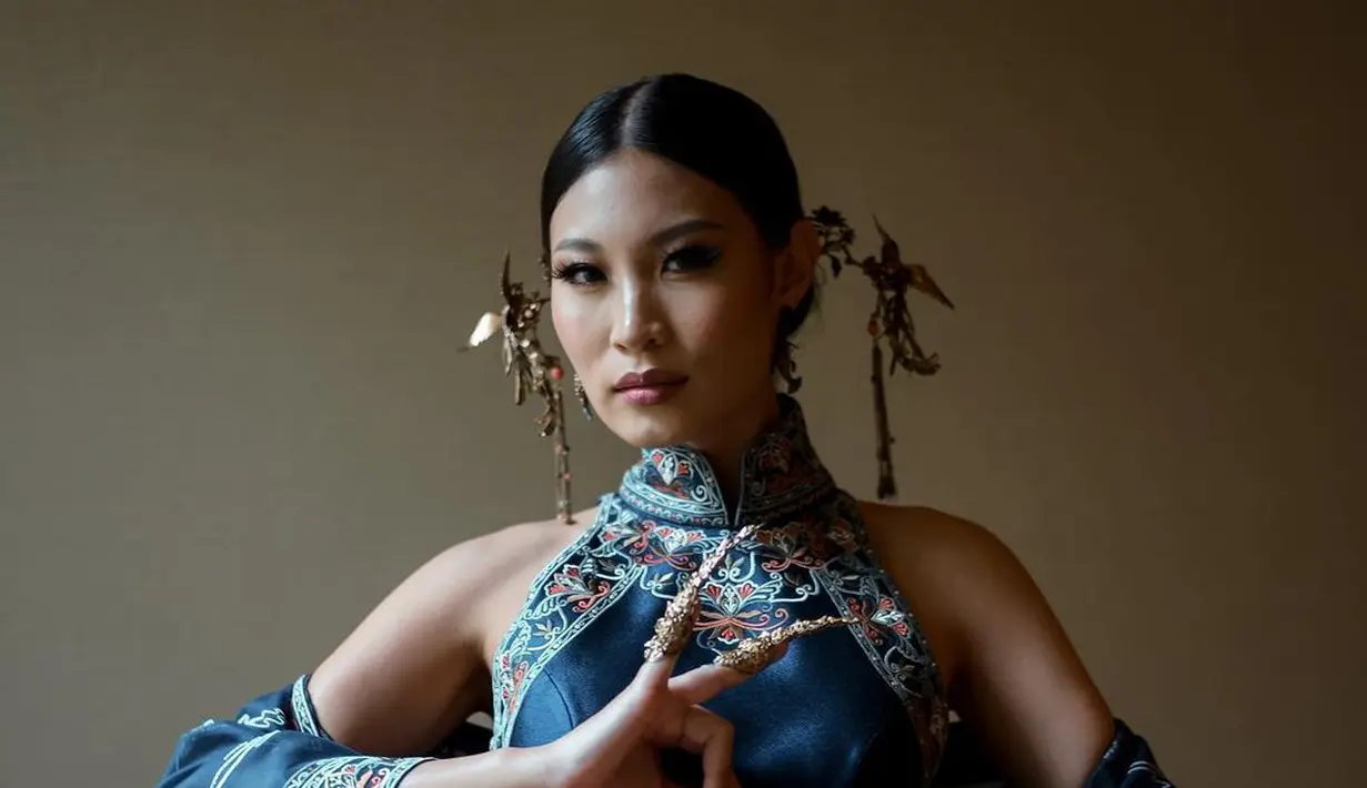 <p>Patricia Gouw mengenakan cheongsam biru rancangan Hian Tjen. Cheongsam ini juga memiliki outer yang semakin membuat penampilan Patgouw megah. [Instagram].</p>