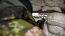 Seorang prajurit Ukraina memantau sebuah pos pemeriksaan dari balik karung pasir di jalan utama di Kyiv, Ukraina, 7 Maret 2022. PBB tidak dapat memenuhi kebutuhan jutaan warga sipil yang terjebak dalam konflik di Ukraina. (AP Photo/Vadim Ghirda)