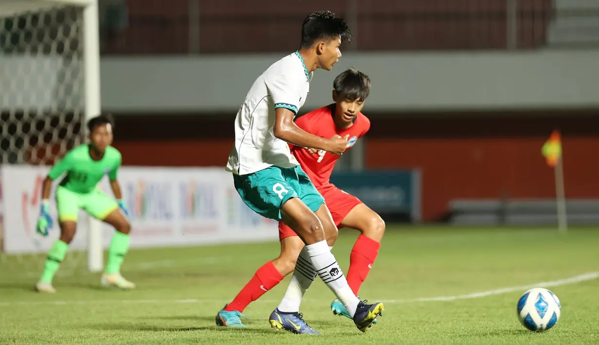 Pemain timnas Indonesia U-16 Arkhan Kaka Putra Purwanto (kiri) berebut bola dengan pemain timnas Singapura U-16 pada laga Grup A Piala AFF U-16 2022 di Stadion Maguwoharjo, Rabu (3/8/2022). Pasukan Bima Sakti membantai Singapura U-16 dengan skor telak 9-0. (FOTO: Dok. PSSI)