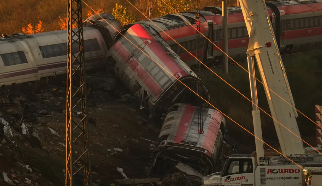 Sejumlah derek mengangkat gerbong kereta yang ringsek saat petugas penyelamat mencari korban di lokasi tabrakan dua kereta di Urda, Spanyol, Kamis (29/10/2026). (AP Photo/Manu Fernandez)