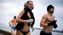 Peserta wanita mengikuti lomba Underpants Run di tepi sungai Danube di Beograd, Serbia (4/2). Dengan hanya mengenakan pakaian dalam para peserta tetap semangat mengikuti lomba dengan suhu mendekati nol derajat Celcius. (AFP Photo/Andrej Isakovic)