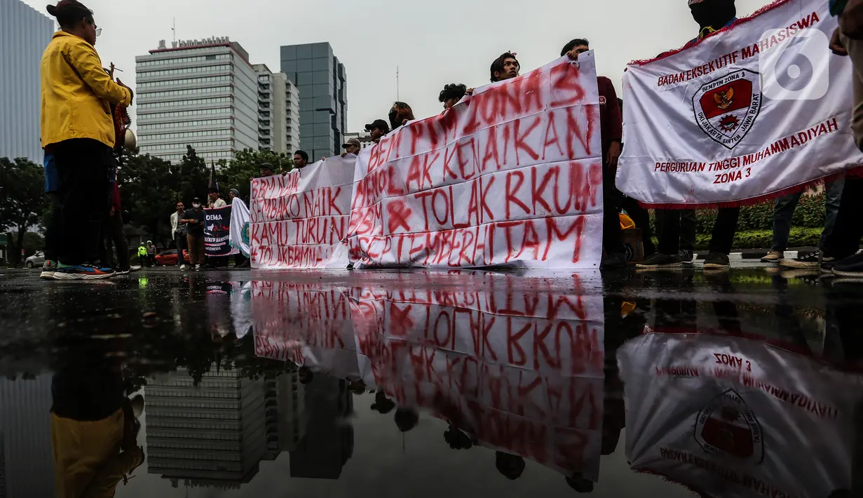 Mahasiswa membentangkan spanduk penolakan kenaikan harga BBM saat menggelar demo di kawasan Patung Kuda, Jakarta Pusat (Jakpus), Kamis (8/9/2022). Pihak kepolisian tetap mengawal jalannya aksi dengan membuat pertahanan berlapis. (Liputan6.com/Johan Tallo)