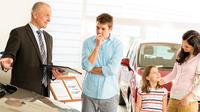 Penjual mobil sedang menawarkan kendaraan ke pasangan muda. (Shutterstock/CandyBoxImages)