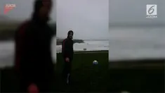 Seorang pemuda lakukan eksperimen unik, ia menendang bola berlawanan dengan arah angin untuk mengetahui sejauh mana kekuatan badai.