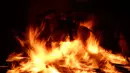 Seorang pria menunggangi kuda melewati api unggun saat festival Luminarias di San Bartolome de Pinares, Spanyol, Jumat (16/1/2020). Biasanya tradisi berkuda menembus api dilakukan pada satu hari sebelum perayaan Santo Antonius, yakni pada malam hari hingga tengah malam. (AP Photo/Manu Fernandez)