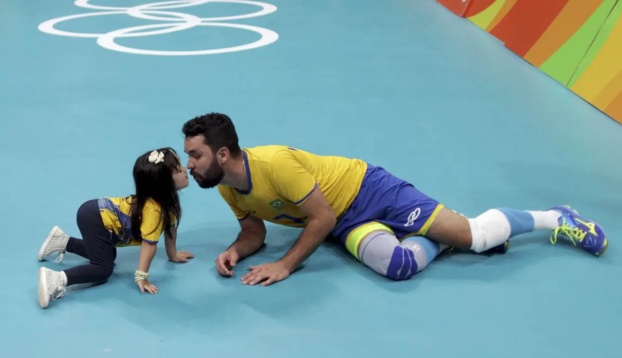 Pevoli Brasil, William, melakukan selebrasi unik dengan sang putri usai menaklukkan Rusia pada semifinal Olimpiade 2016 di Maracanazinho, Brasil, Sabtu (20/8/2016). Brasil menang 3-0 atas Rusia. (Reuters/Ricardo Moraes)