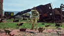 Seorang tentara Ukraina dan beberapa ekor kucing berdiri dengan latar belakang kendaraan militer Rusia yang rusak di Pulau Ular, Laut Hitam, Ukraina, 18 Desember 2022. Pasukan Rusia menduduki pulau itu pada awal-awal invasinya ke Ukraina, namun akhirnya mundur beberapa bulan kemudian. (AP Photo/Michael Shtekel)