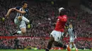 Pemain West Bromwich, Ahmed Hegazy (kiri) membuang bola dari kejaran pemain Manchester United, Romelu Lukaku pada lanjutan Premier League di Old Trafford, Manchester,(15/4/2018). Manchester United kalah 0-1. (AFP/Paul Ellis)