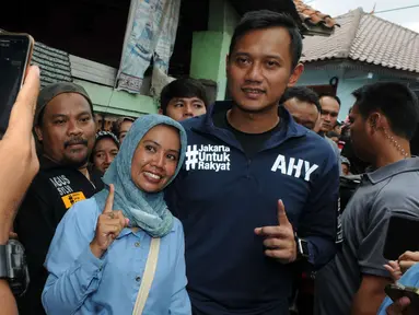 Calon Gubernur DKI Jakarta Agus Harimurti Yudhoyono berfoto bersama warga saat mengunjungi perkampungan Tegal Parang, Mampang Prapatan, Jakarta, Selasa (7/12). AHY dicurhati warga sekitar seputar penyelesaian masalah banjir. (Liputan6.com/Helmi Afandi)
