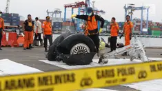 Petugas menyemprot cairan pada bagian roda pesawat Lion Air PK-LQP JT 610 di Pelabuhan JICT 2, Jakarta, Senin (5/11). Bagian tersebut dipindah untuk dilakukan identifikasi dan pengecekan lebih lanjut oleh KNKT. (Liputan6.com/Helmi Fithriansyah)