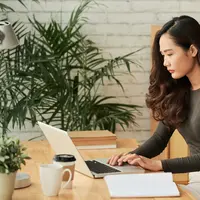 Seorang perempuan sedang bekerja menggunakan laptopnya (Foto Dok: Freepik/pressfoto).