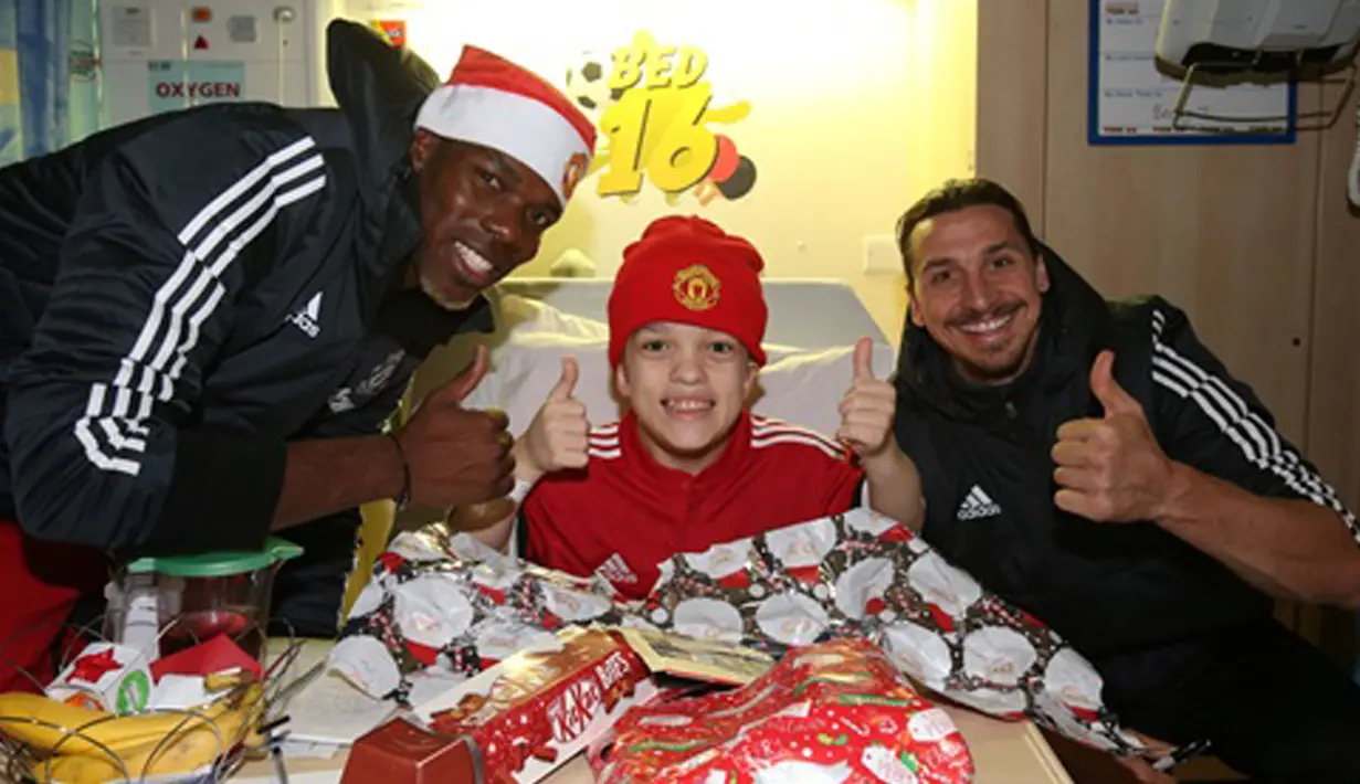 Pemain Manchester United, Zlatan Ibrahimovic dan Paul Pogba membagikan hadiah Natal saat mengunjungi Rumah Sakit Anak di Manchester, (18/12/2017). (Bola.com/Dok.Manutd.com)