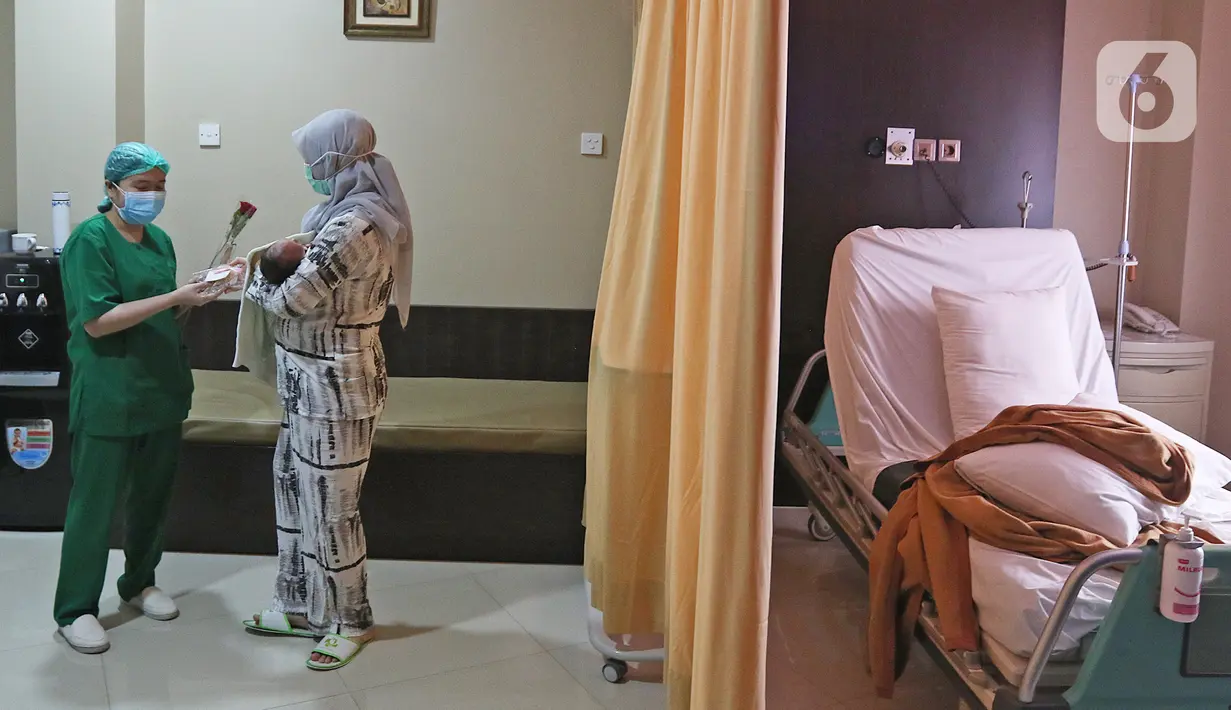 Perawat memberikan bunga dan kue ke pasien rawat inap di Rumah Sakit Ibu dan Anak Tambak, Jakarta, Selasa (22/12/2020). Pemberian bunga dan kue kepada pasien rawat inap dan pasien yang kontrol dilakukan untuk memperingati perayaan Hari Ibu yang jatuh pada 22 Desember. (Liputan6.com/Herman Zakharia)