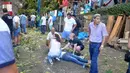 Warga memberi pertolongan kepada korban pohon tumbang di Funchal, Portugal (15/8). Sebuah pohon ek atau oak berusia 200 tahun tumbang dan menimpa kerumunan orang yang berada di sebuah alun-alun di wilayah sub-urban Funchal. (AFP Photo/Rui Silva)